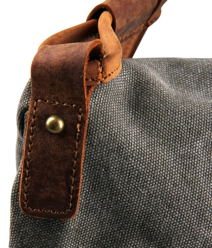Another Detail of a leather loop on the flap of a gray canvas bag for women